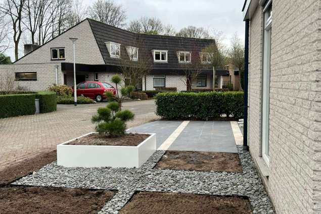 Voortuin aanleggen in Tilburg met witte planten bakken en keramische tegels 