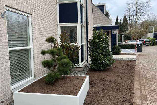 Voortuin aanleggen in Tilburg met witte planten bakken en keramische tegels 