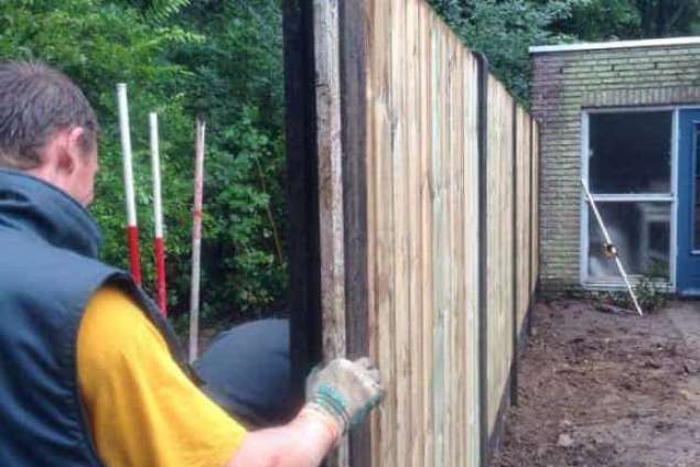 waterpas zetten schutting van betonplaten en houten tuinschermen 21 planks of 23 planks
