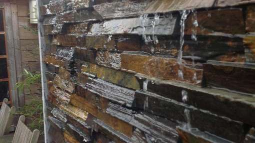 strak waterelement van muurstrips in een tuin in Udenhout aangelegd door medewerkes van a van spelde hoveniers