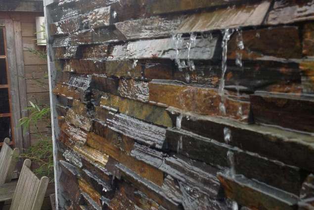 strak waterelement van muurstrips in een tuin in Udenhout aangelegd door medewerkes van a van spelde hoveniers