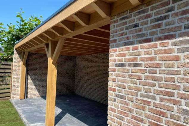 Luxe tuinoverkapping met eiken balken steekschoren sedum dak en keramische tegel vloer