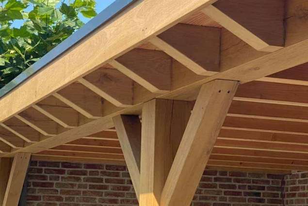 Luxe tuinoverkapping met eiken balken steekschoren sedum dak en keramische tegel vloer