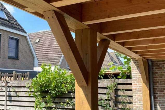 Luxe tuinoverkapping met eiken balken steekschoren sedum dak en keramische tegel vloer