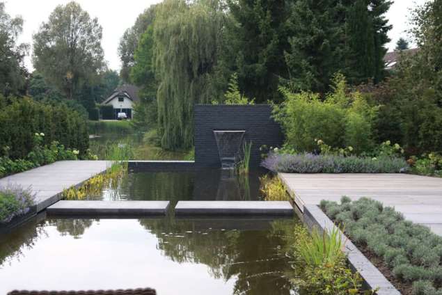 zwevende tegels over het water betontegels 200*100x14 antrasiet, gemetselde vijverrand hovenier tilburg brabant utrecht welke planten passen in een strakke tuin