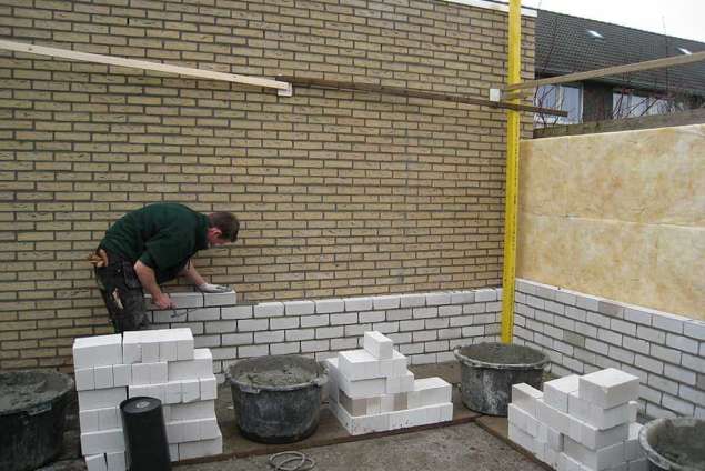 Metselen van spuawmuur voor een tuin huis met schuur 