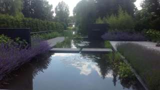 Het plaatsen van een geschilderde tuinmuur, u ziet hier door de tuinmuur meer diepte, de tuinmuur geeft ook een beschut terras.