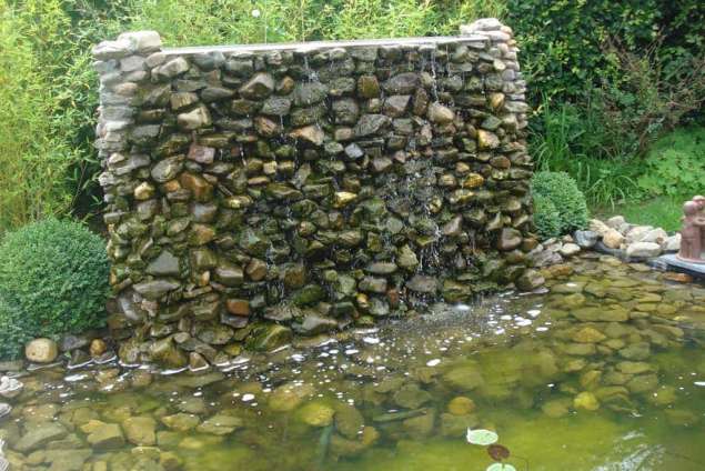 heldere vijver, watermuur gebouwd met betonstenen en een goot van rvs hovenier tilburg udenhout