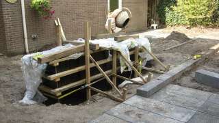 stellen van de bak voor de betonmuur met rvs waterelement de platen zijn van aziatisch multie betonplex de wanden zijn ingeolied met bekistingsolie maken bekisting voor betonmuur strak en modern tuinontwerp