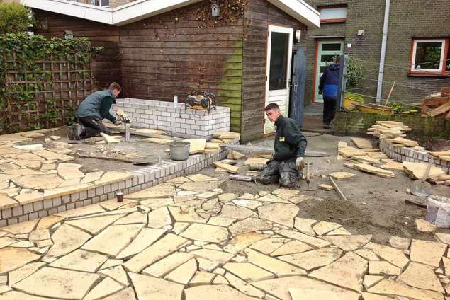 leveren en leggen van flagstone vastlijmen van flagstones tegen een muur,  flagstones in de tuin. waalwijk reeshof maaspoort de blaak amsterdam utrecht rotterdam spijkenisse waarle, invoegen van flagstone hovenier