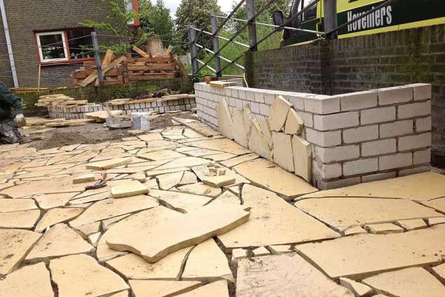 invoegen van flagstones hoe leg ik flagstones in de tuin. 80 m2 flagstones leggen in vlaardingen esbeek hilvarenbeek.  vastbranden van de tegels met lijm aan de ondergrond