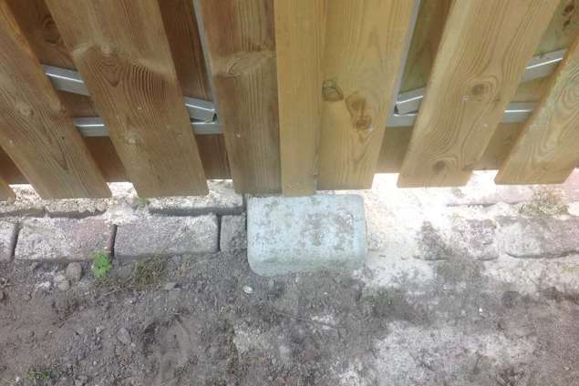 betonnen aanslag voor het niet kunnen doorslaan van de tuinpoort. plank om en om gemonteerd op een stalen frame in Waalwijk Best Schijndel Oisterwijk Vught tuinontwerp Breda