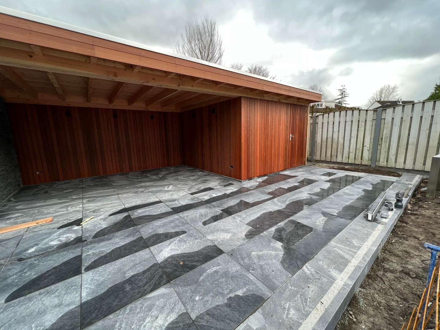 0000nieuws/2022/19-2-ellen/keramische-tuintegels-leggen-met-luxe-maatwerk-tuinoverkapping-60x60-tegels-achtertuin-1