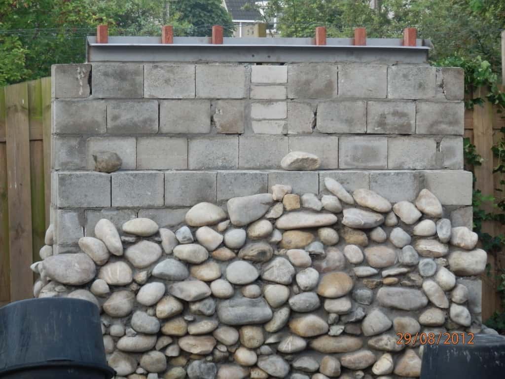 004regenwulp/vastzetten van natuursteen op een betonnenmuur waterval maken