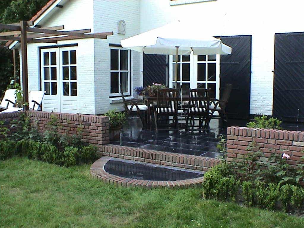 marloes/5 traptrede 15 cm . overang van een natuurstene terras naar groen grasvell